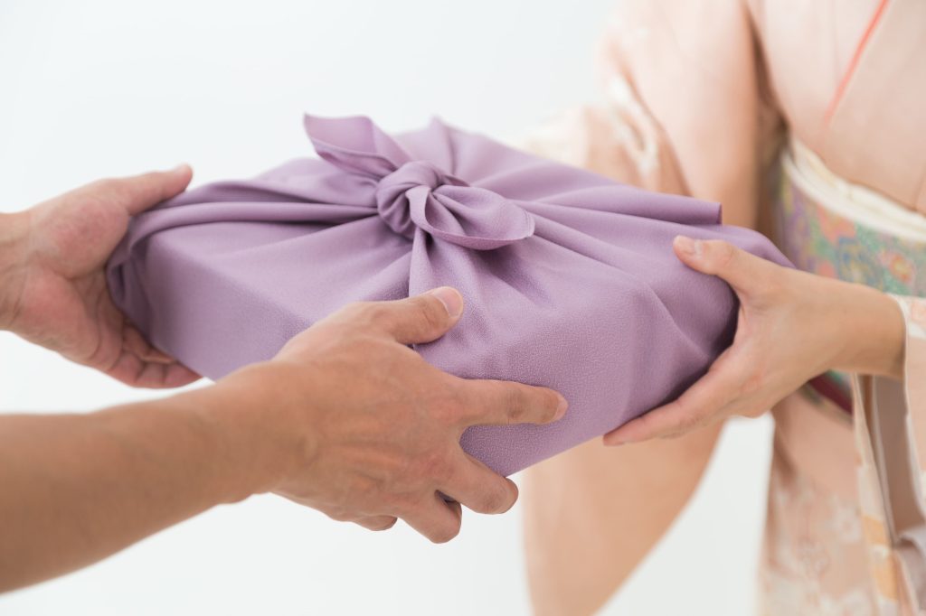 日本の夏の風物詩、お中元ギフトを着物の女性が渡すシーン